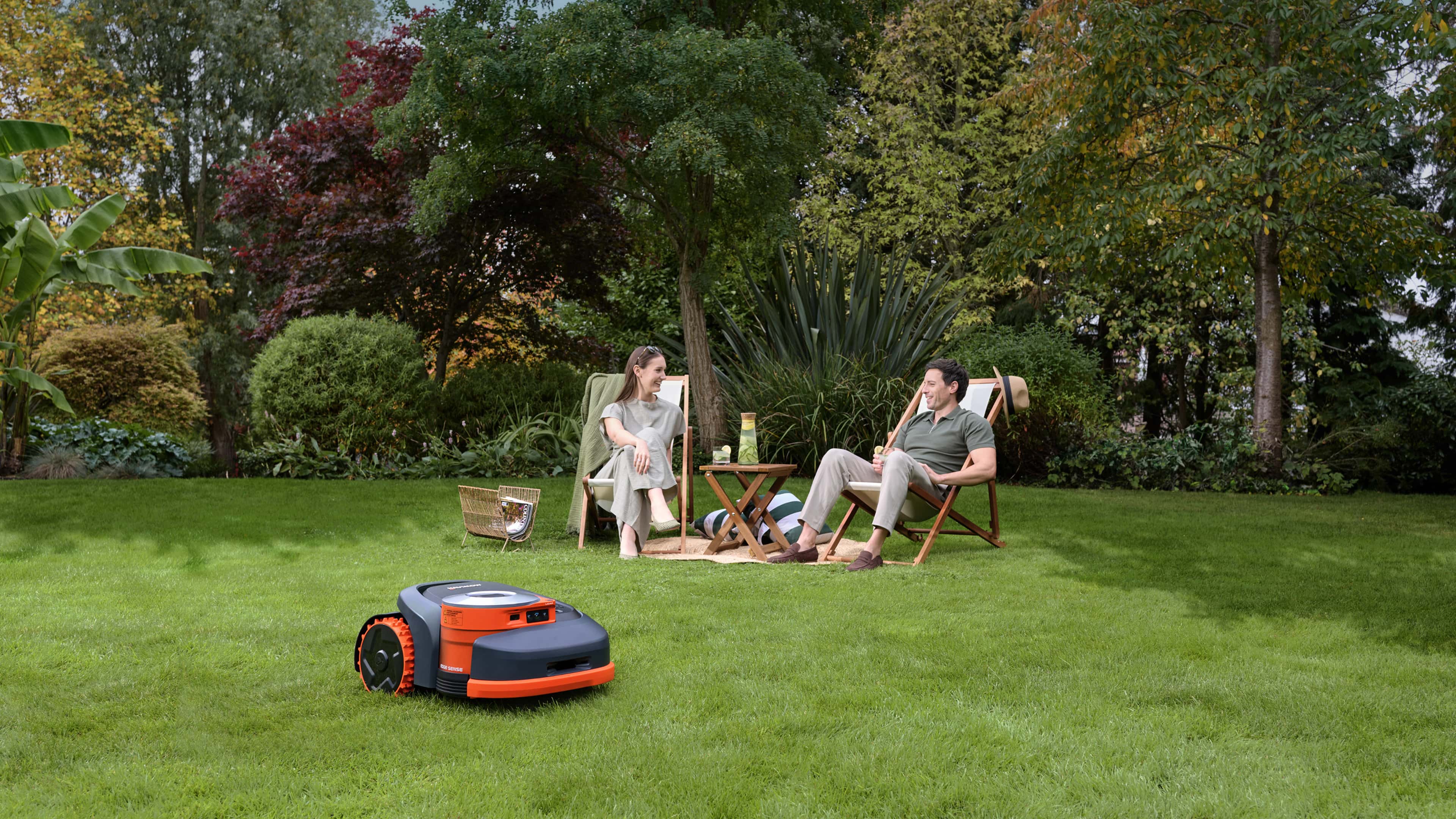 Navimow i110E robot lawn mower works while the couple relaxes.