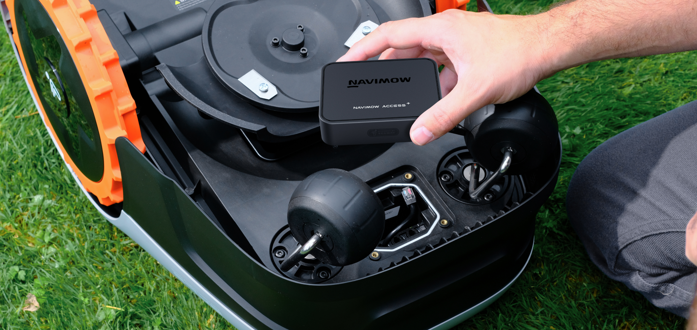 Navimow Access+ robot lawn mower module being held by hand.