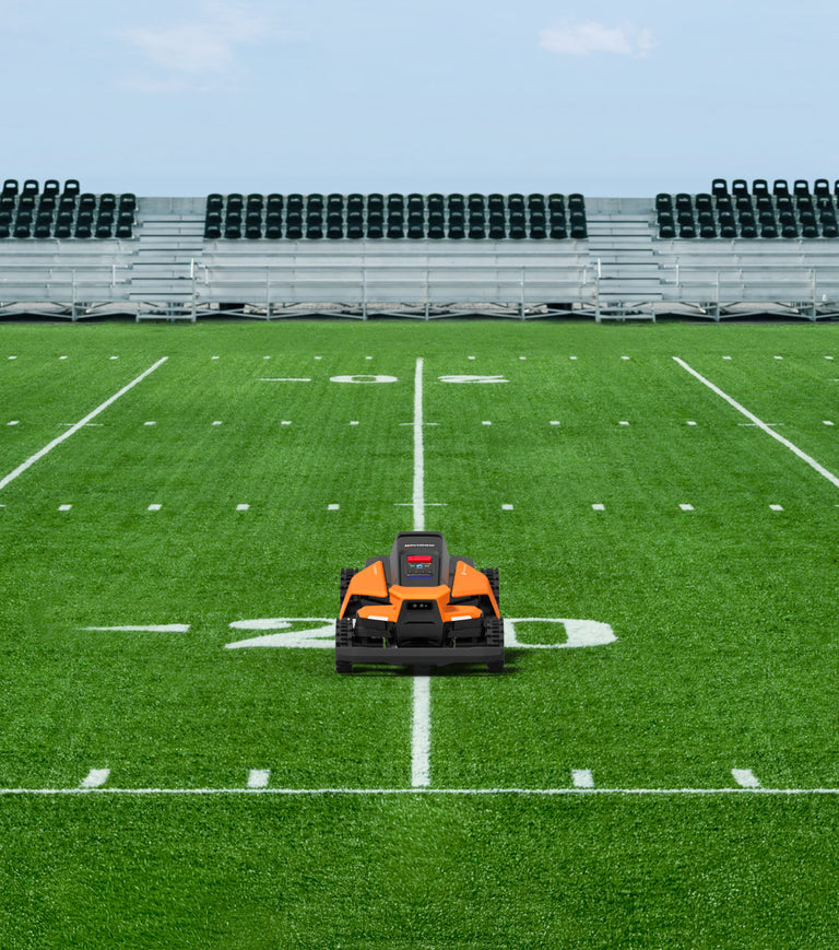 Navimow i110N robot lawn mower on a green football field.