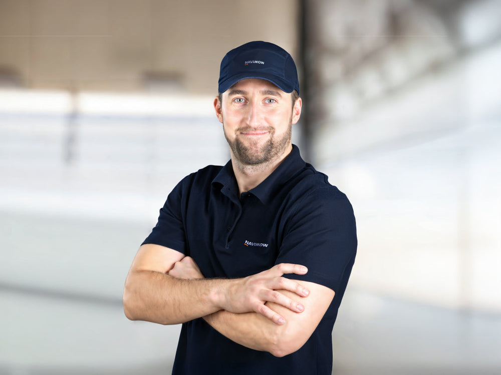 Navimow i105 robot lawn mower brand ambassador in work uniform.