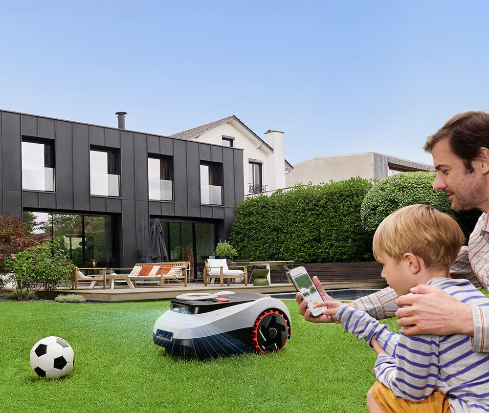 Segway Navimow i110N robot lawn mower on the backyard grass.