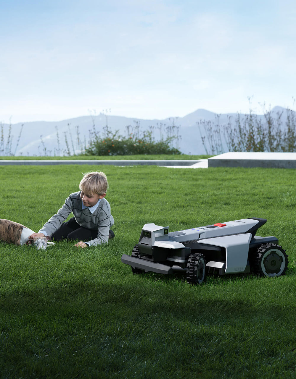 Navimow i110N robot lawn mower with a boy and dog.